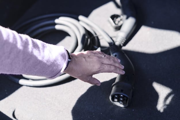 A close-up shot of a person plugging an electric vehicle charging cable into an EV, with a focus on the charging port and cable connection.