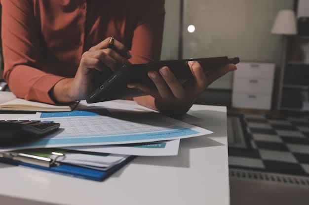 A person using a calculator and reviewing financial documents to estimate their potential unemployment benefits, with a focus on accuracy and detail.