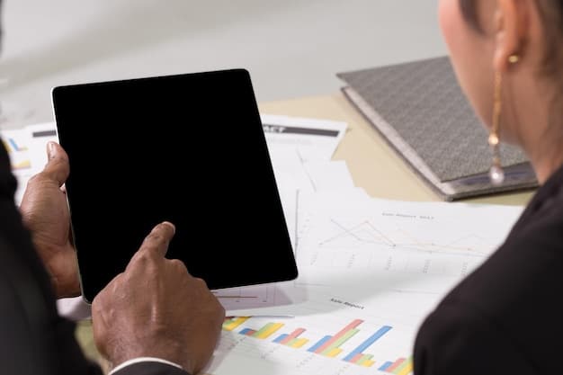 A close-up shot of a business person reviewing a financial spreadsheet on a tablet, with graphs and charts visible. The lighting is focused on the screen.
