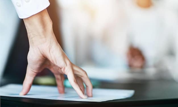A close-up of a banker's hands on a financial document, with a blurred background showing a busy trading floor. The document has charts and graphs, symbolizing risk assessment and compliance. The lighting is professional and highlights the importance of the paperwork.